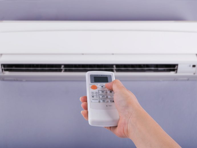 hand-holding-remote-control-directed-air-conditioner